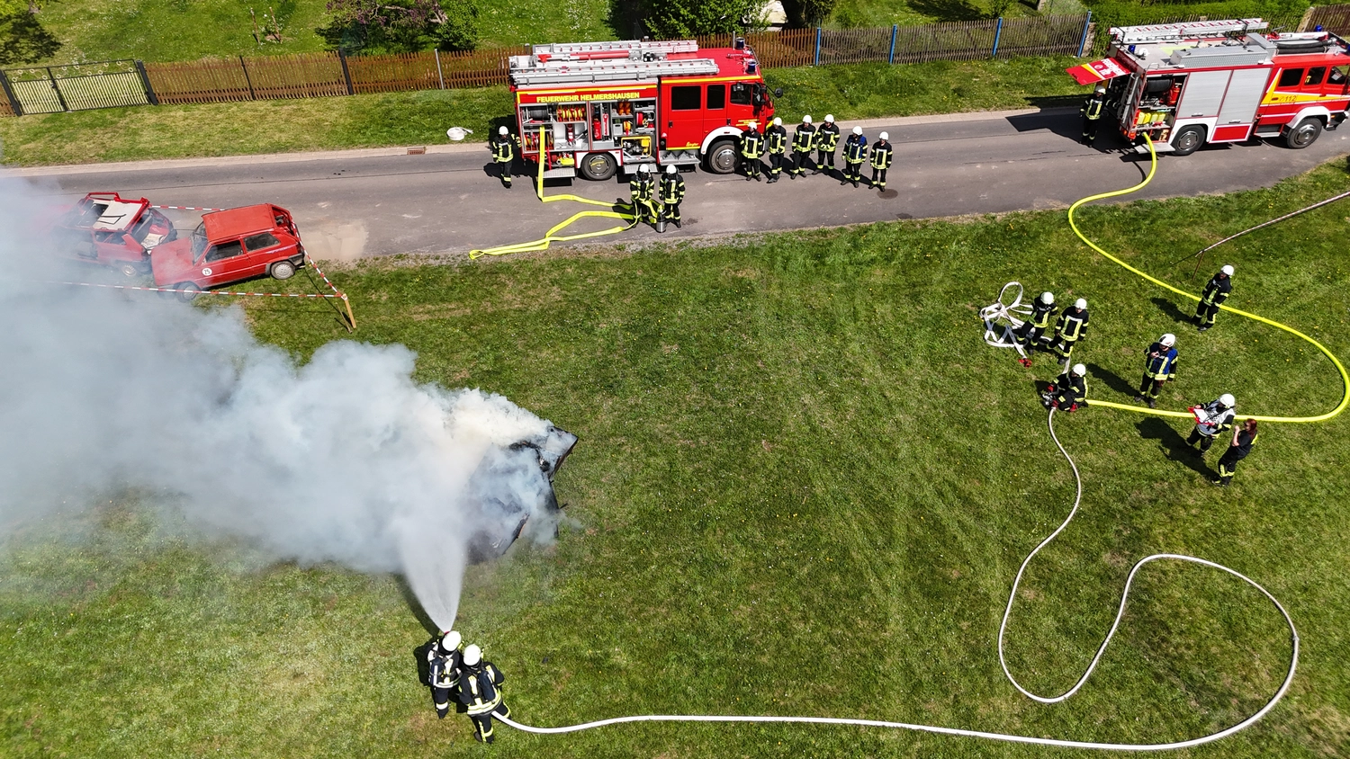 Kreisfeuerwehrverband Schmalkalden-Meiningen e.V. - Koordiniert die Aktivitäten und Veranstaltungen der Feuerwehr - Ein rot-weißes Volvo-Feuerwehrauto parkt vor einer blauen Feuerwache.